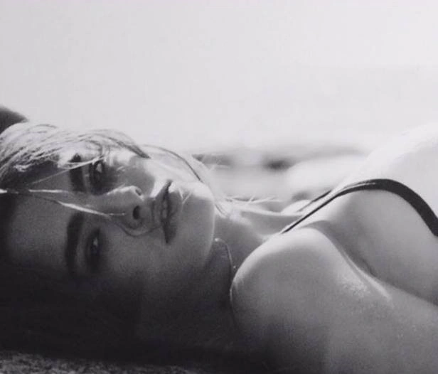 May Gil model laying on the beach.